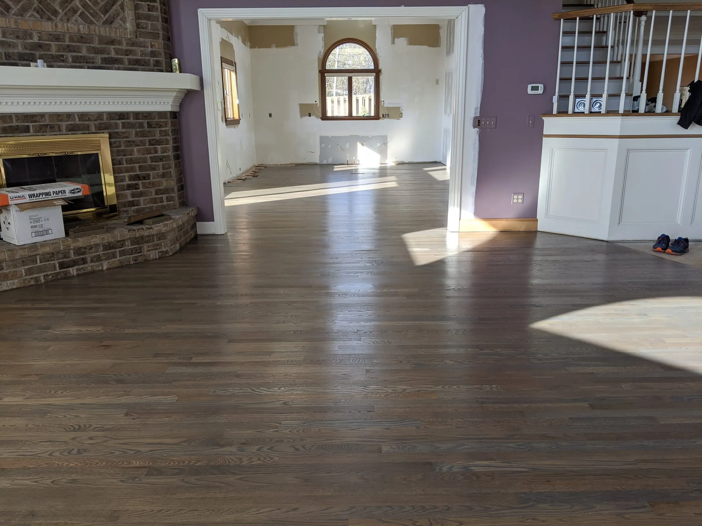 Living room oak floor refinished in a gray-brown stain beside a brick fireplace