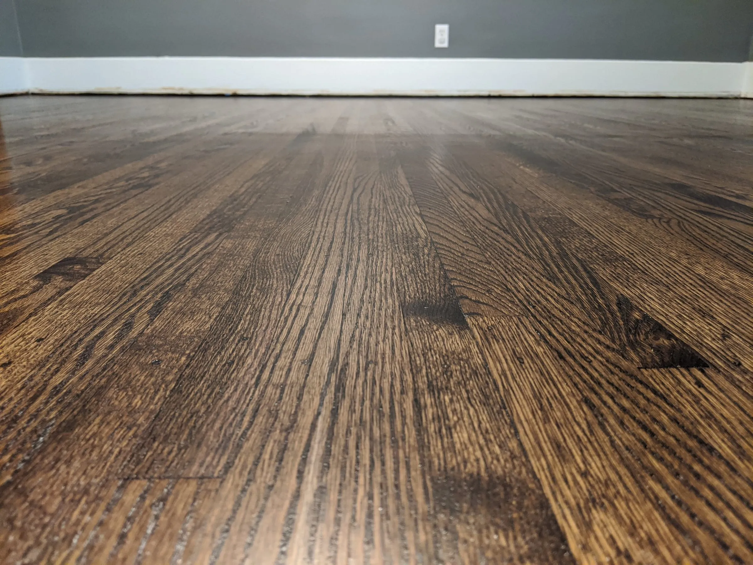 Close-up of dark-stained oak floor showing open grain