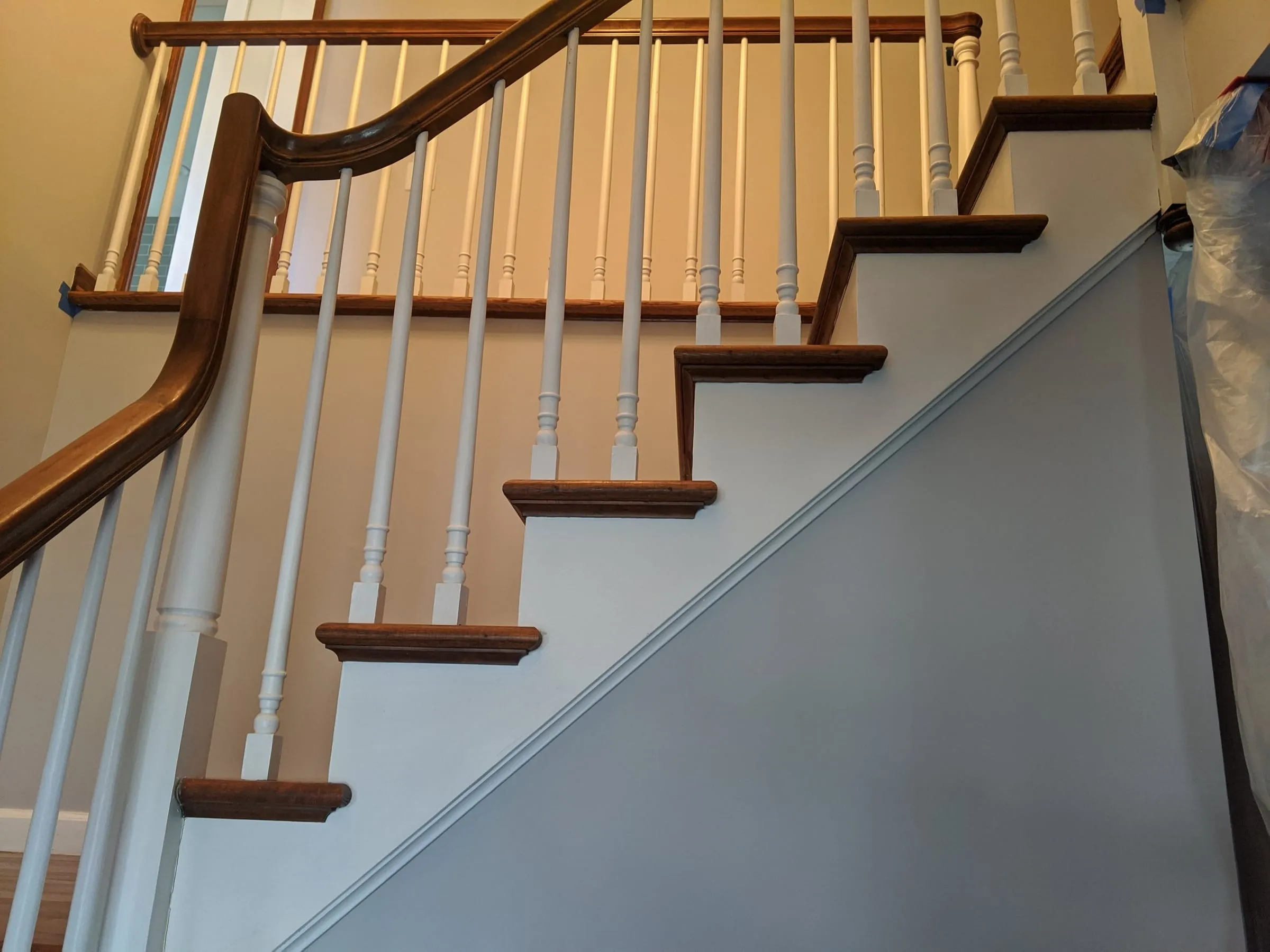 Stair stringer with refinished oak treads and white balusters