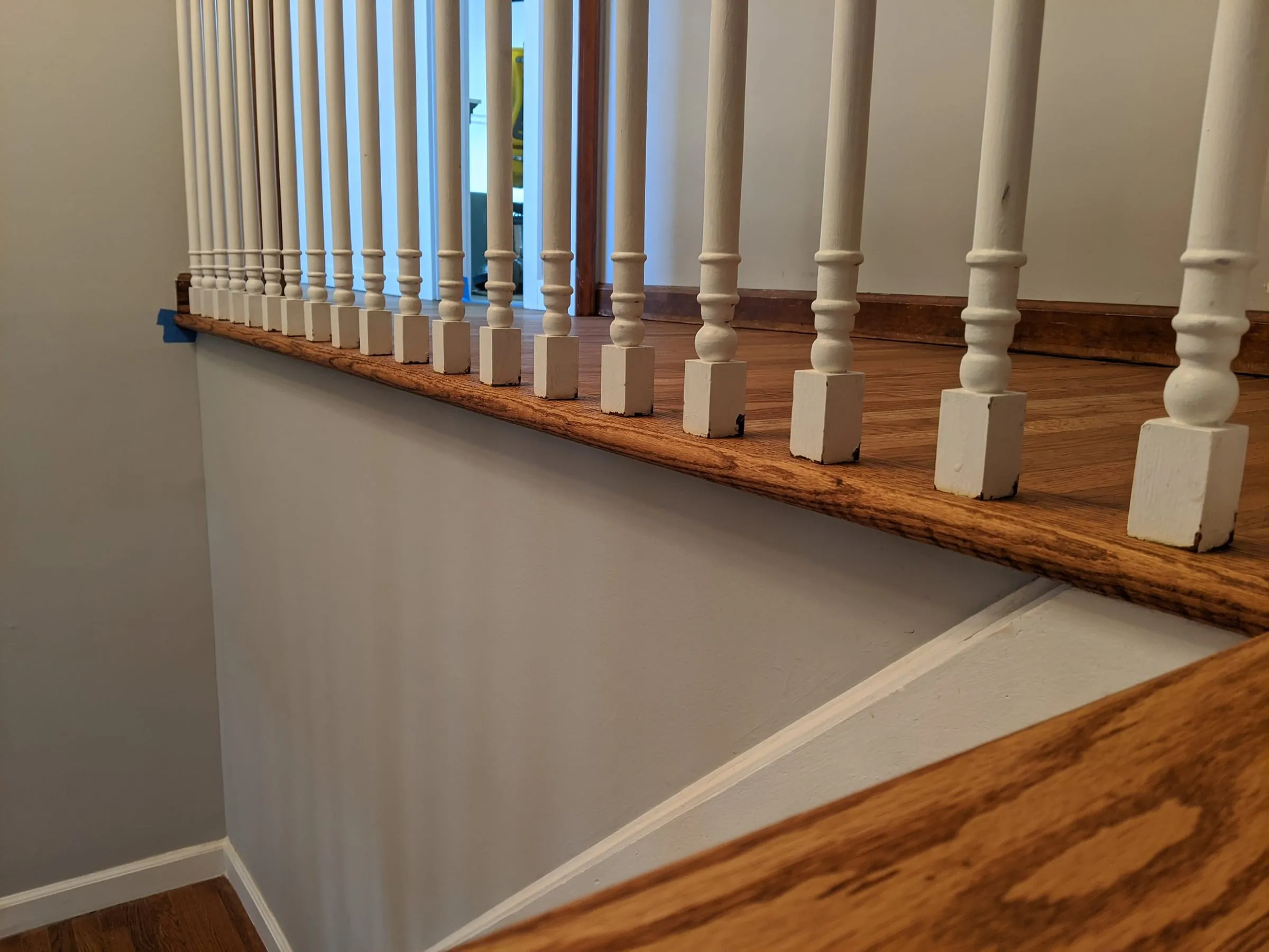 Oak stair nosing and landing edge with white turned balusters