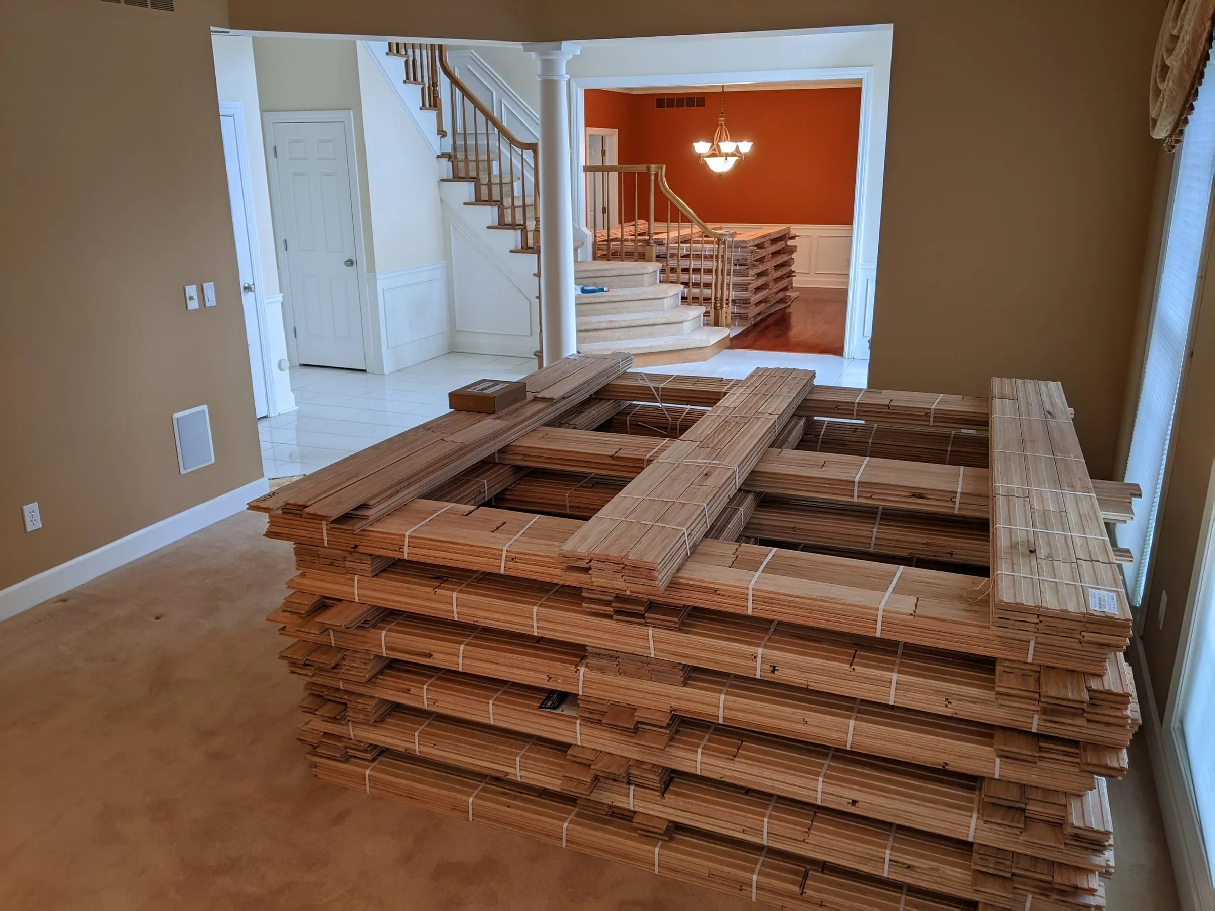 Pallets of new hardwood flooring acclimating in an empty room