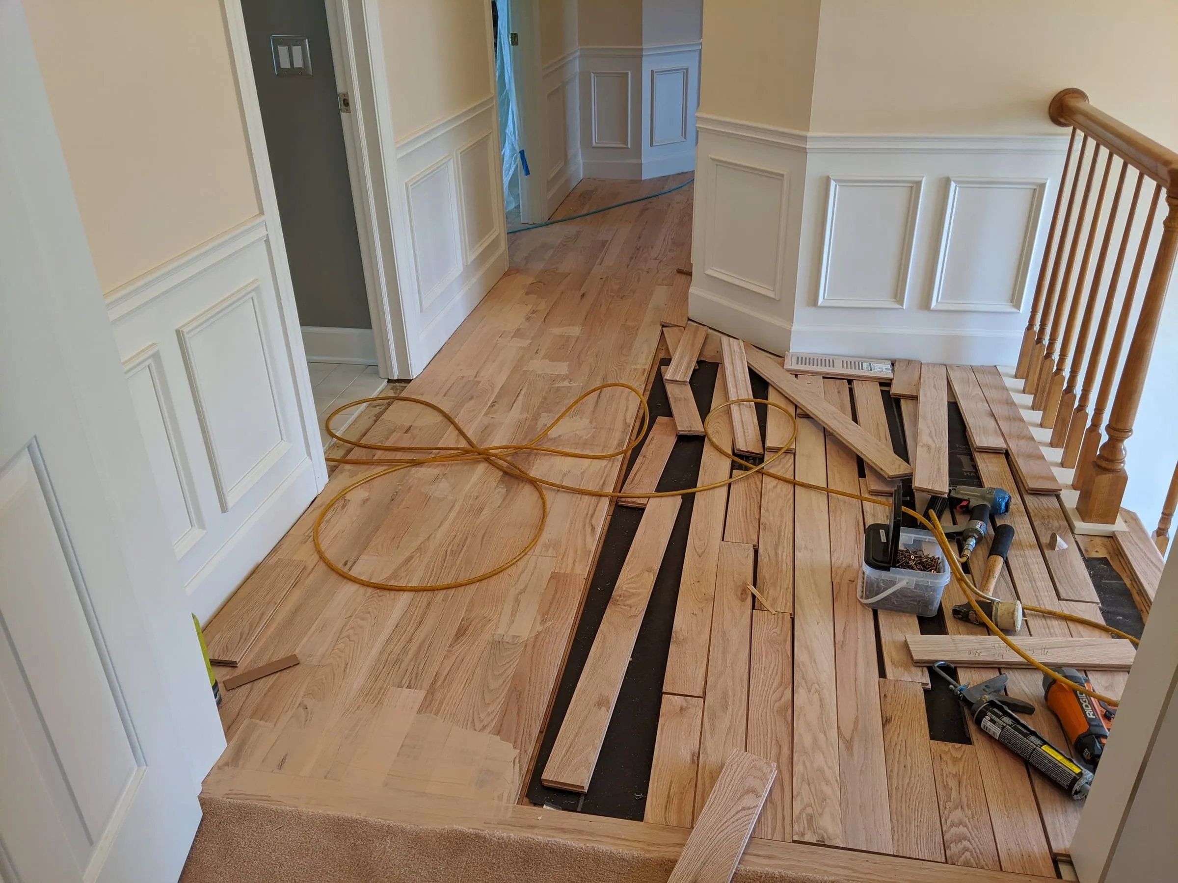 New oak boards being installed along an upstairs landing