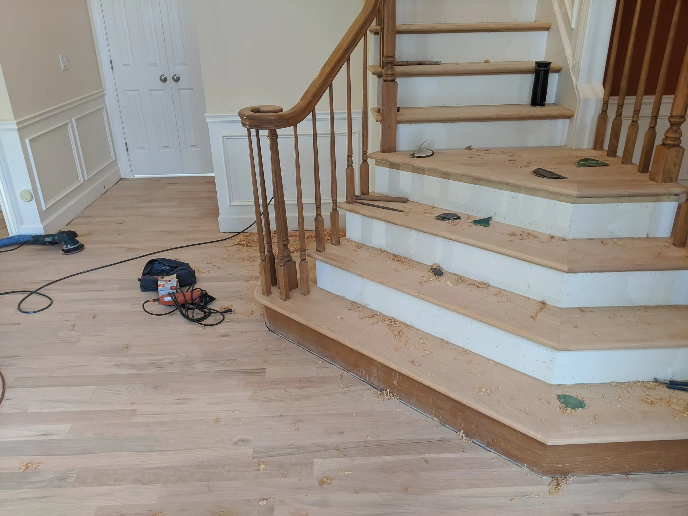 Bare new oak treads on a curved staircase during installation
