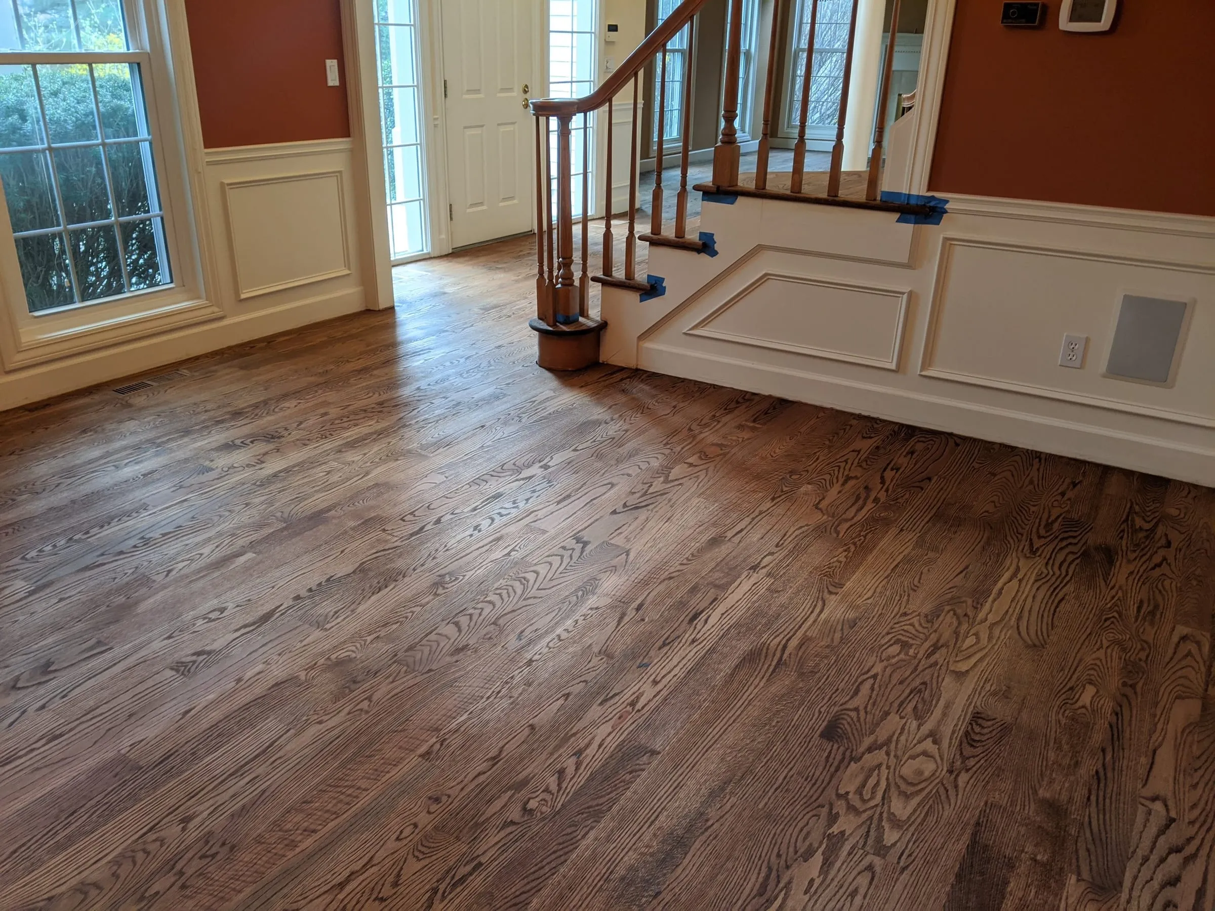 Foyer with a newly refinished brown-stained oak floor