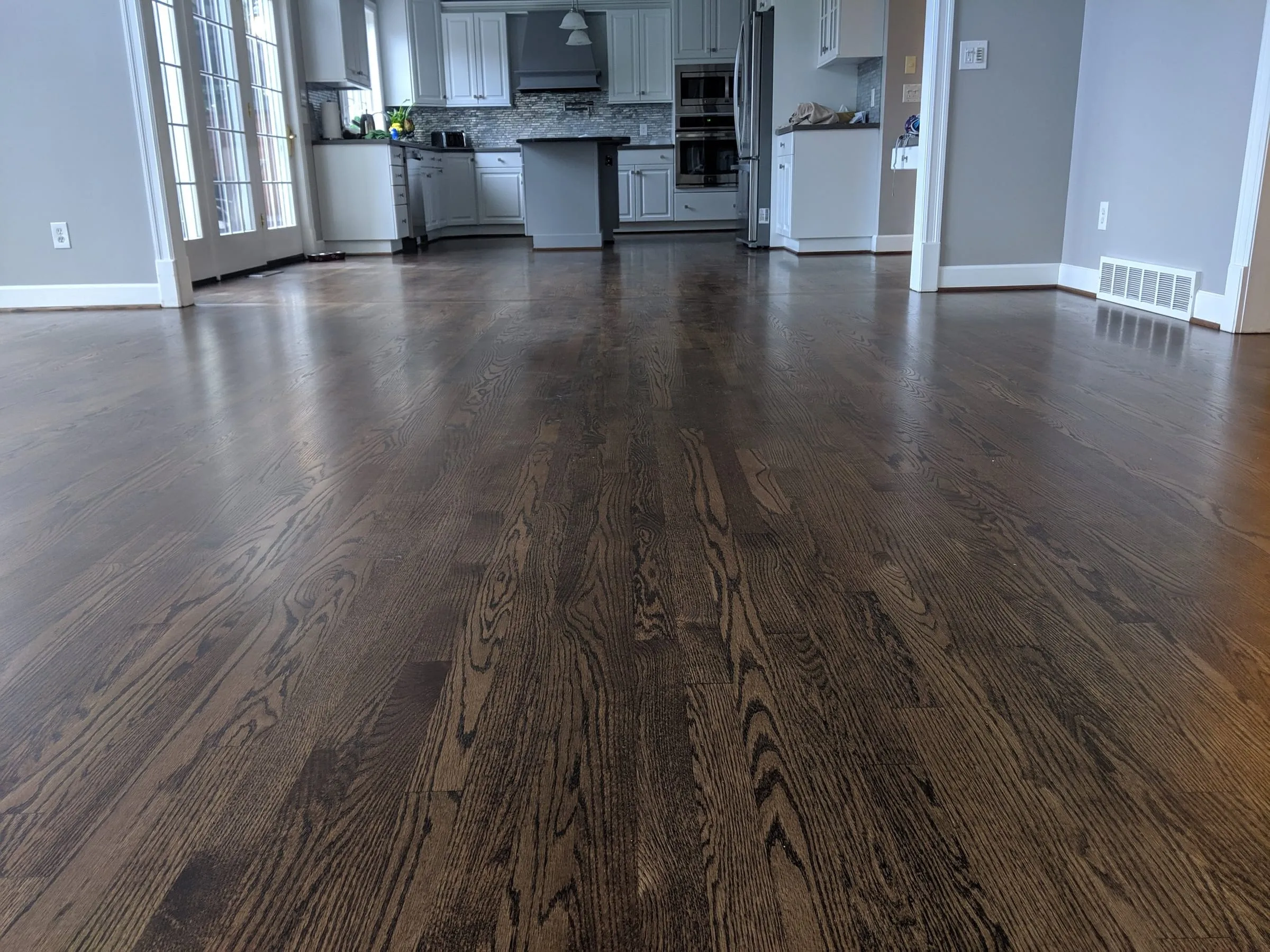 Dark-stained oak floor in an open kitchen and living area