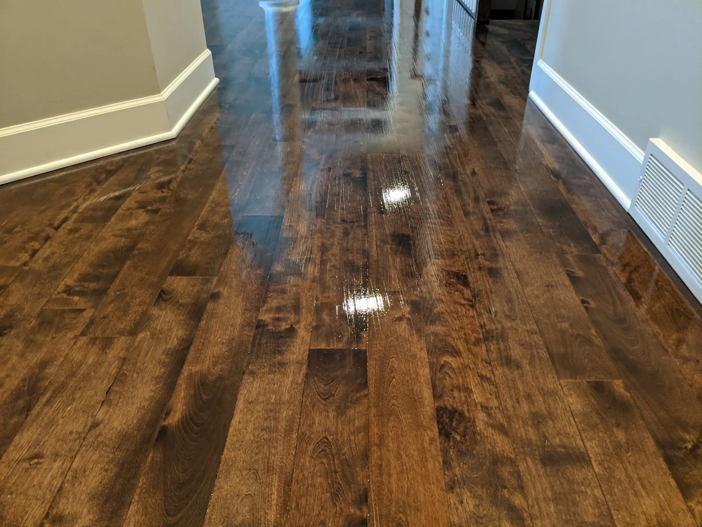 Close-up of high-gloss dark hardwood showing the grain