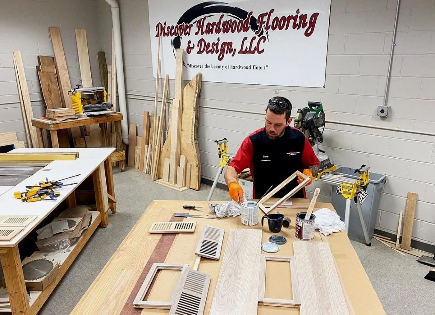 Stephan Sykes building custom wood floor vents at a workbench in the Discover Hardwood shop